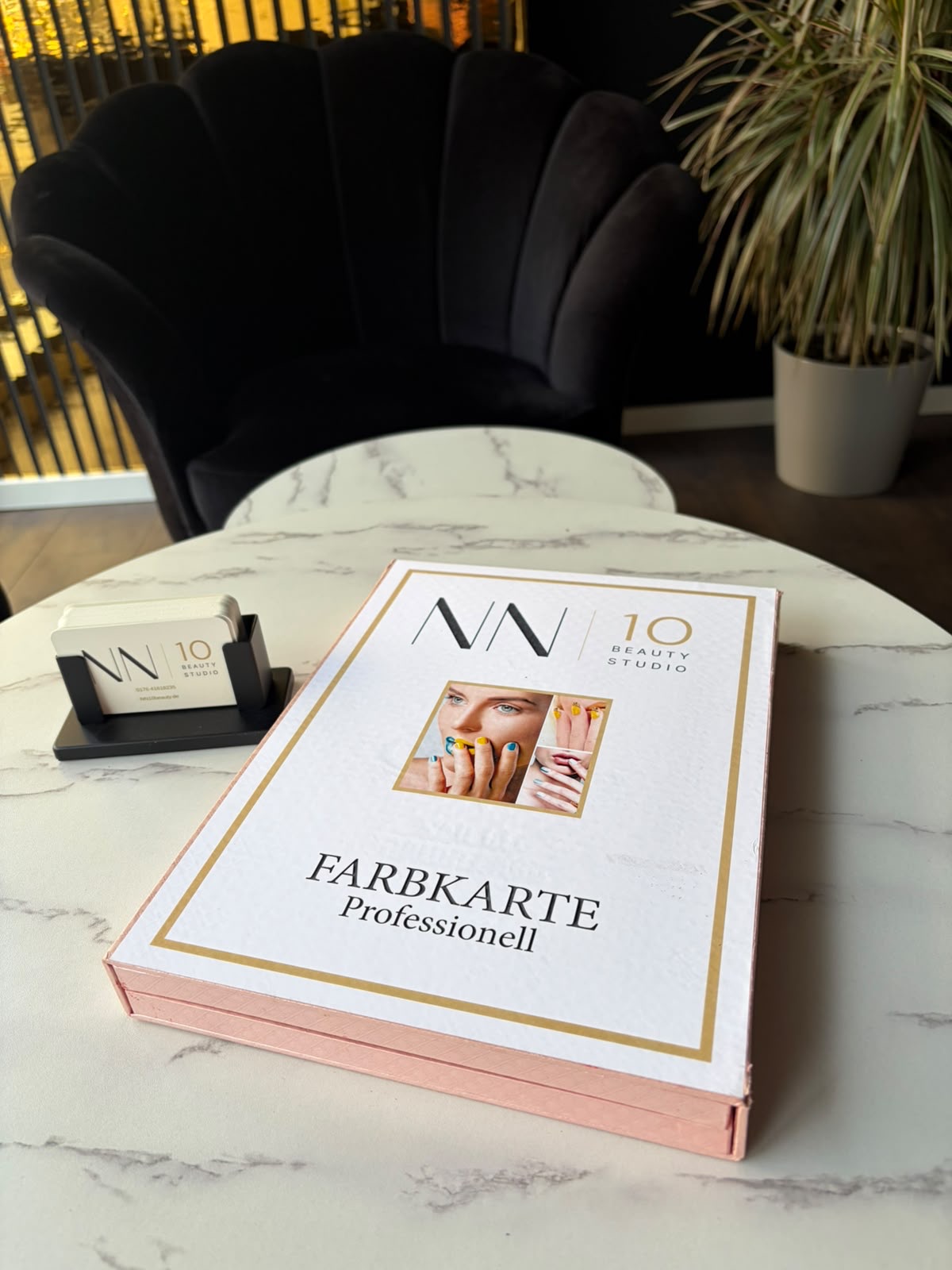 Farbkarte des NN10 Beauty Studios auf einem Marmortisch — zur Auswahl des Wunschtons vor der Behandlung