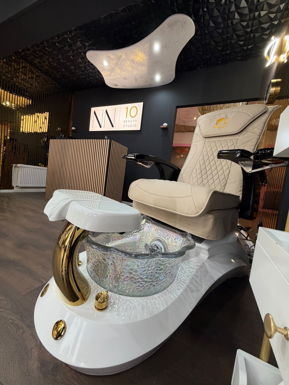 Pediküre-Sessel im NN10 Beauty Studio — cremefarbenes Polster, Glas-Fußbecken und goldene Armatur