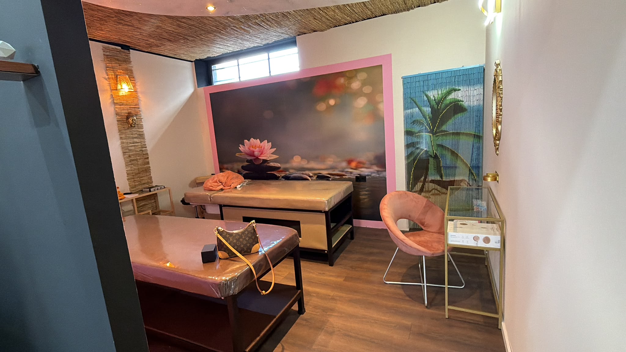 Ruheraum für Massagen im NN10 Beauty Studio — zwei Massageliegen, warmes Licht und Seerosen-Wandbild